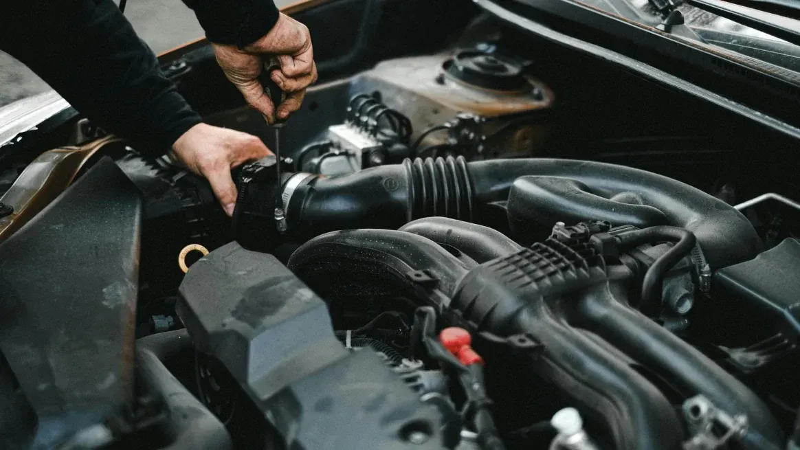 Technician Inspecting Vehicle Engine Technician Inspecting Vehicle Engine