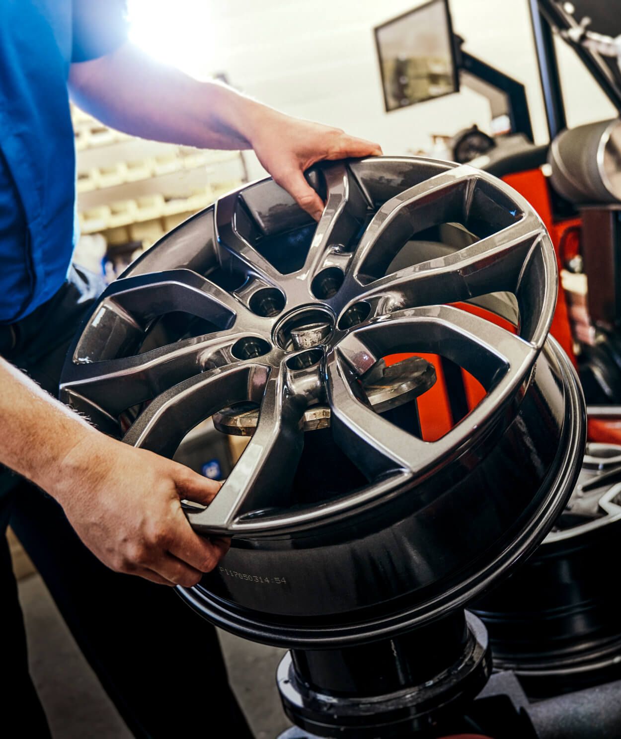 Close-up of dark grey alloy wheel rim in a service center.