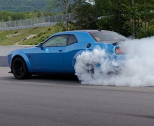 Blue Dodge Challenger performing a burnout