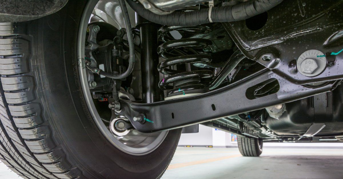 A close-up of a parked car. The black suspension components underneath the car look clean and functional.
