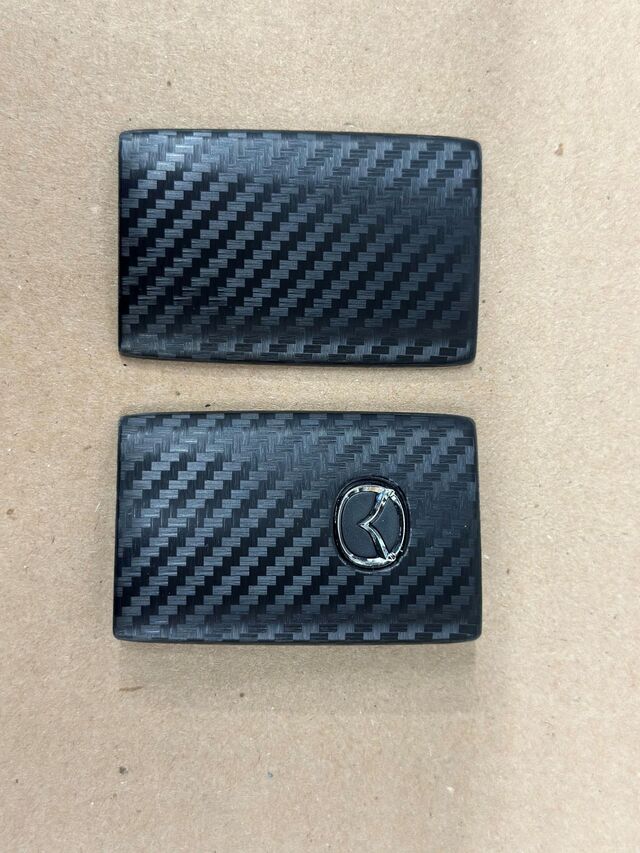 C9N1V0450 - Security: Key Fob Cover - Carbon Fiber for Mazda: 3, CX-30, CX-5, CX-50, CX-70, CX-9, CX-90, MX-30 EV Image