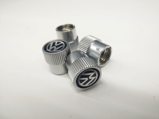 71215J - Wheels: Valve Stem Caps - Black On Silver for Volkswagen: Arteon, Atlas, Beetle, CC, e-Golf, Eos, Golf, Golf Alltrack, Golf SportWagen, GTI, ID. Buzz, ID.4, Jetta, Passat, Rabbit, Routan, Taos, Tiguan, Tiguan Limited, Touareg Image