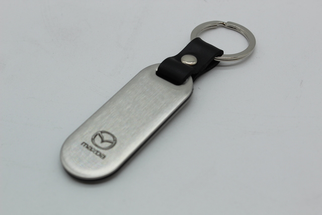 C9N1V0440 - Merchandise: Key Chain, Mazda Logo, Brushed for Mazda: 2, 3, 5, 6, CX-3, CX-30, CX-5, CX-50, CX-7, CX-9, MPV, MX-5 Miata, RX-8, Tribute Image