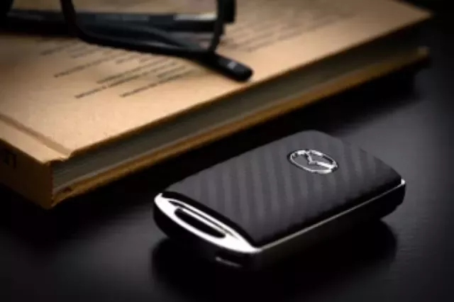 C9N1V0450 - Security: Mazda Key Fob Cover, Carbon Fiber Look for Mazda: 3, CX-30, CX-5, CX-50, CX-70, CX-9, CX-90, MX-30 EV Image