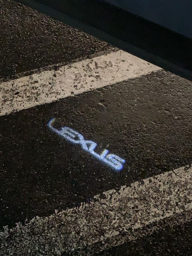 PT94478220 - Exterior: Lexus Puddle Lamp Set RX RZ NX TX Front or Rear Doors 2PC for Lexus: NX250, NX350, NX350h, NX450h+, RX350, RX350h, RX450h+, RX500h Image