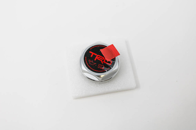 PTR3500110 - TRD: TRD Oil Cap for Scion: iM, tC, xB, xD | Toyota: 4Runner, Avalon, C-HR, Camry, Corolla, Corolla iM, FJ Cruiser, Highlander, Land Cruiser, Matrix, Prius, Prius C, RAV4, Sequoia, Sienna, Solara, Tacoma, Tundra, Yaris Image